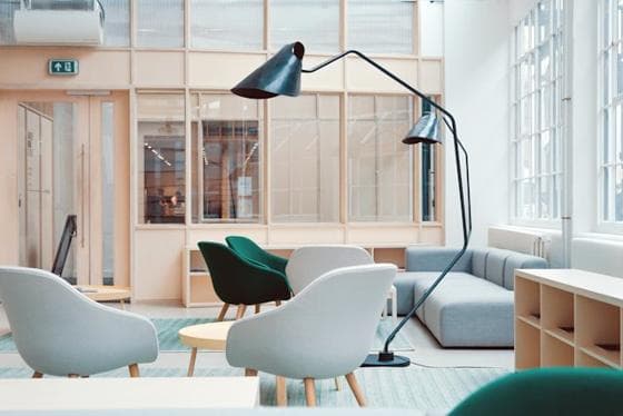 Studio lounge with white chairs and a black floor lamp